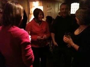 Crowded room of people talking at an evening networking tweetup