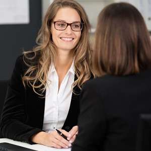 Two women in a coaching conversation at a desk, stock photo