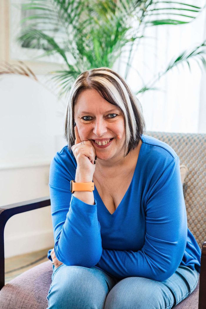 Veronica Pullen headshot in a blue top with her hand under her chin